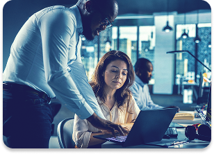 Team members reviewing work on a laptop to improve efficiency and productivity